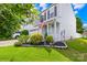 Charming two-story home featuring a well-manicured front yard with beautiful landscaping and an American flag at 8614 Westhope St, Charlotte, NC 28216