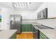 Bright kitchen with stainless steel appliances, green cabinets, and contemporary lighting at 8614 Westhope St, Charlotte, NC 28216