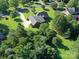 Aerial view of a brick home with a long driveway, set amidst lush greenery and mature trees at 908 Haddonfield Dr, Fort Mill, SC 29708