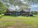 A spacious backyard features well-maintained lawn, shrubs, and a screened-in porch on a brick home at 908 Haddonfield Dr, Fort Mill, SC 29708