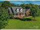 A charming red brick home featuring a well-manicured lawn and a welcoming front porch with white columns at 908 Haddonfield Dr, Fort Mill, SC 29708