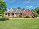 A classic brick home with black shutters, a green lawn, and a welcoming front porch with white trim at 908 Haddonfield Dr, Fort Mill, SC 29708