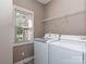 Bright laundry room featuring a window, wire rack shelving, and washer and dryer at 908 Haddonfield Dr, Fort Mill, SC 29708