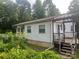 Exterior view of home showing siding, porch with pergola, and overgrown shrubbery at 9314 Seymour Ln, Davidson, NC 28036