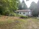 Quaint one-story home with a swing and covered porch nestled among mature trees in a serene setting at 9314 Seymour Ln, Davidson, NC 28036
