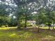 Exterior view of home showing it set back from the street among mature trees at 9314 Seymour Ln, Davidson, NC 28036