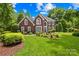 Charming brick home with lush green lawn and mature trees, showcasing classic architectural details at 9514 Hayenridge Ct, Huntersville, NC 28078