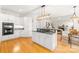 Bright kitchen with white cabinets, granite countertops, double wall ovens, island with cooktop and hardwood floors at 9514 Hayenridge Ct, Huntersville, NC 28078