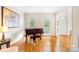 Bright living room featuring hardwood floors, a piano, and large windows with natural light at 9514 Hayenridge Ct, Huntersville, NC 28078