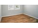 Cozy bedroom with wood floors, neutral paint, white trim, and a window providing natural light at 9846 Quercus Ln, Huntersville, NC 28078
