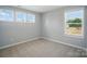 A bright bedroom features carpeted floors and multiple windows that provide natural light at 9846 Quercus Ln, Huntersville, NC 28078