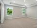 A bright bedroom with plush carpeting, recessed lights, and natural light from the windows at 9846 Quercus Ln, Huntersville, NC 28078