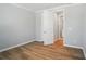 Bright bedroom with wood floors, neutral paint, white trim, and an open door to an ensuite bathroom at 9846 Quercus Ln, Huntersville, NC 28078