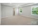 Bedroom featuring carpeted floors, tray ceiling and natural light from dual windows at 9846 Quercus Ln, Huntersville, NC 28078