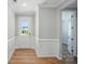 Inviting entryway with wood floors, white wainscoting, neutral paint, and a view into an adjacent room at 9846 Quercus Ln, Huntersville, NC 28078