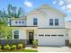 Stunning two-story home with white siding, stone accents, lush landscaping, and an attached two-car garage at 9846 Quercus Ln, Huntersville, NC 28078