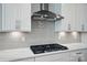 Close up of gas range in kitchen with white cabinets, backsplash and quartz countertops at 9846 Quercus Ln, Huntersville, NC 28078