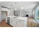 Modern kitchen island with stainless steel appliances, white cabinets, open to the living space at 9846 Quercus Ln, Huntersville, NC 28078