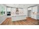 Bright kitchen featuring white cabinets, quartz countertops, modern appliances, and hardwood flooring at 9846 Quercus Ln, Huntersville, NC 28078