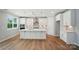 Bright kitchen with white cabinets, modern appliances, central island, and hardwood flooring at 9846 Quercus Ln, Huntersville, NC 28078