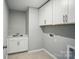 This laundry room features white cabinets, a utility sink, and convenient hookups for your washer and dryer at 9846 Quercus Ln, Huntersville, NC 28078