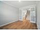 Spacious living room with hardwood floors, neutral paint, and french doors leading to the staircase and kitchen at 9846 Quercus Ln, Huntersville, NC 28078