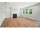 Cozy living room with fireplace, hardwood floors, and natural light from large windows at 9846 Quercus Ln, Huntersville, NC 28078