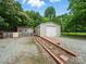 Backyard featuring mature trees, a metal garage, and a small storage shed at 1015 Rhode Island Ave, Kannapolis, NC 28083