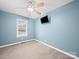 Bedroom with neutral carpet, ceiling fan, window, and a mounted television at 1015 Rhode Island Ave, Kannapolis, NC 28083