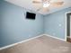 Bedroom with neutral carpet, ceiling fan, window, and a mounted television at 1015 Rhode Island Ave, Kannapolis, NC 28083