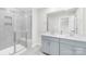 Bathroom with a tiled shower, double sink vanity, and gray cabinets at 1022 Maltby St, Charlotte, NC 28217