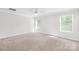 Spacious bedroom with neutral carpet, two large windows, and ceiling fan at 1022 Maltby St, Charlotte, NC 28217