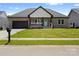 Charming, single-story home with brick exterior, blue door, black garage door, and well-maintained lawn at 103 Wadesborough Pl, Wadesboro, NC 28170