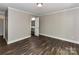 A clean bedroom featuring wood-look floors, neutral walls, and an ensuite bathroom entrance at 1117 Hidden Brook Ln, Clover, SC 29710
