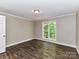 Neutral bedroom featuring wood-look floors, a large window with tree views, and a light fixture at 1117 Hidden Brook Ln, Clover, SC 29710