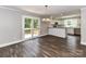 Open concept living and kitchen area with wood floors, breakfast bar, and sliding doors to deck at 1117 Hidden Brook Ln, Clover, SC 29710