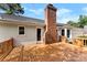 Relaxing back deck with a brick chimney, offering a serene outdoor retreat with views of the landscaped backyard at 118 Creek Hollow Trl, Belmont, NC 28012