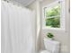 Bathroom with a toilet, a window, and a shower and bath with a white shower curtain at 118 Creek Hollow Trl, Belmont, NC 28012
