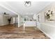 Bright open-concept living area with wood plank flooring, flowing into the kitchen with white cabinets at 118 Creek Hollow Trl, Belmont, NC 28012