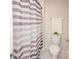Bathroom including a toilet with decorative items, and a purple and white striped shower curtain at 128 Hickory Ridge Dr, Locust, NC 28097