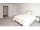This is a bedroom with neutral carpet, one small side table, and a bed with a white quilt at 128 Hickory Ridge Dr, Locust, NC 28097