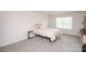 A bedroom with a queen bed, a side table, and a window that provides natural light at 128 Hickory Ridge Dr, Locust, NC 28097