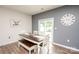 Bright dining area featuring a wood table with bench, gray accent wall, and sliding door at 128 Hickory Ridge Dr, Locust, NC 28097