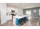 Stylish kitchen featuring a central island with barstools, white cabinets, and an adjacent dining area at 128 Hickory Ridge Dr, Locust, NC 28097