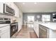 Bright and airy kitchen with modern appliances, a central island, and an open layout into the dining area at 128 Hickory Ridge Dr, Locust, NC 28097