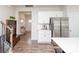 Modern kitchen with stainless steel appliances, white cabinets, and hardwood floors; view toward entry and stairs at 128 Hickory Ridge Dr, Locust, NC 28097