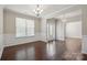 Open dining area with wainscoting, elegant chandelier, and hardwood flooring at 128 Yellowbell Rd, Mooresville, NC 28117