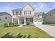 Charming two-story home with black shutters, lush landscaping and a two car garage at 128 Yellowbell Rd, Mooresville, NC 28117
