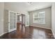 Bright living room featuring hardwood floors, large windows, and an elegant chandelier at 128 Yellowbell Rd, Mooresville, NC 28117