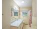 Bathroom with light yellow tile and cabinets at 1332 Midwood Dr, Gastonia, NC 28052